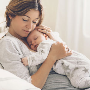 Frau mit Baby im Bett